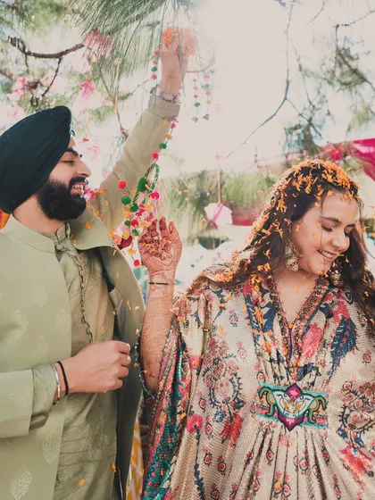 A moment of pure joy. The bride's flowing kaftan is perfect for a relaxed and fun-filled Haldi and Mehendi ceremony.