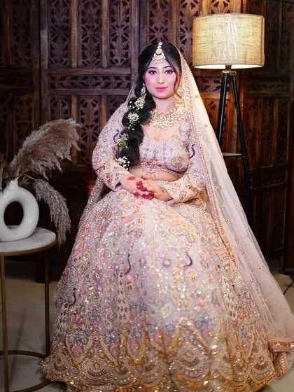 Feel like a queen on your throne in this heavily embroidered pastel bridal lehenga. The full ghera and intricate work make it a true showstopper.