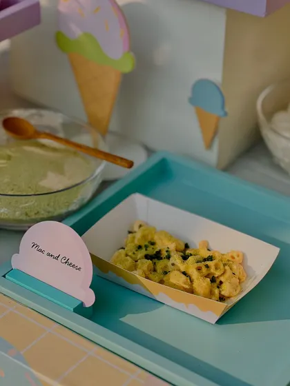 Creamy mac and cheese served in individual portions, a perfect kid-friendly savory option for the party.