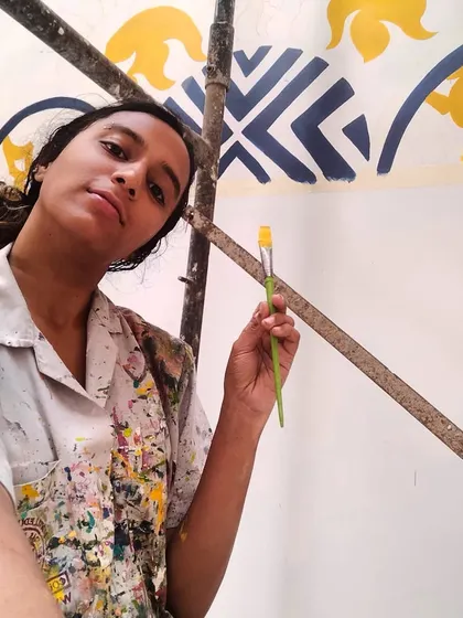 A moment of focus amidst the scaffolding. My paint-splattered shirt is a testament to the passion poured into every detail of this large-scale Kalamkari mural.
