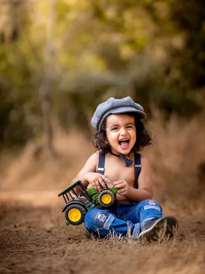 The happiest little guy with his toy tractor. Outdoor sessions are perfect for energetic toddlers who love to play and explore.