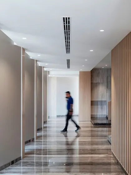 The corridors at Stone Boulevard are designed with a rhythmic pattern of wall panels and integrated lighting. The goal was to guide visitors through the space and create a sense of journey.