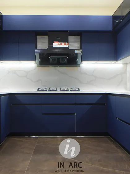 A full view of this modern blue kitchen. The U-shaped layout maximizes counter and storage space, while under-cabinet lighting ensures the workspace is always well-lit.