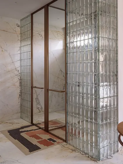The shower and WC stall are enclosed by stunning glass bricks, reminiscent of a high-end trial room, adding a touch of sexy glamour to the space.