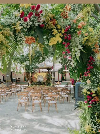 A beautiful, framed view of the Haldi ceremony entrance arch, showcasing the vibrant mix of flowers and greenery that welcomed guests.