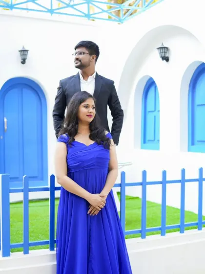 A classic pre-wedding pose against a clean, white and blue architectural background. It's simple, elegant, and timeless.