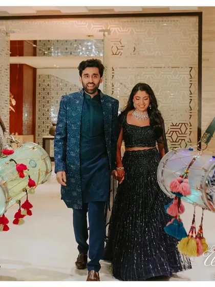 The couple making their Sangeet entrance flanked by dhol players with LED-lit drums.