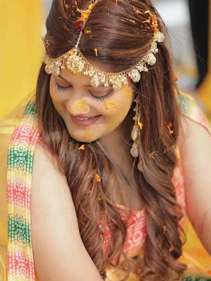 A candid shot of Ishita during her Haldi ceremony, with turmeric on her face. Her soft makeup still looks beautiful and intact.
