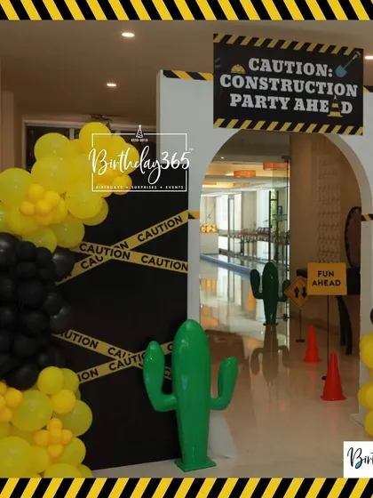The entrance to the construction party, with a "Caution: Construction Party Ahead" sign and yellow and black balloon columns.