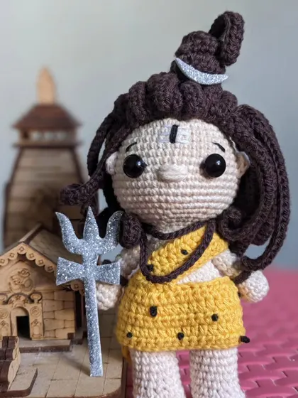 The Lord Shiva doll placed next to a small wooden temple, creating a devotional scene.