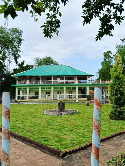 A view of the completed lawn in front of the main building, framed by striped pillars.