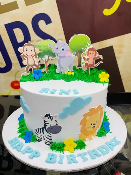 A 2kg jungle cake with a clean white background and cheerful animal toppers.