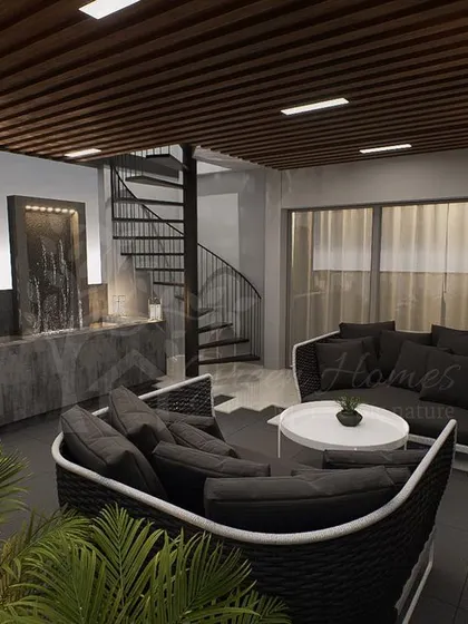 A wider shot of the Ashok Vihar terrace, showing the relationship between the seating lounge, the water feature, and the spiral staircase, creating a cohesive and functional layout.