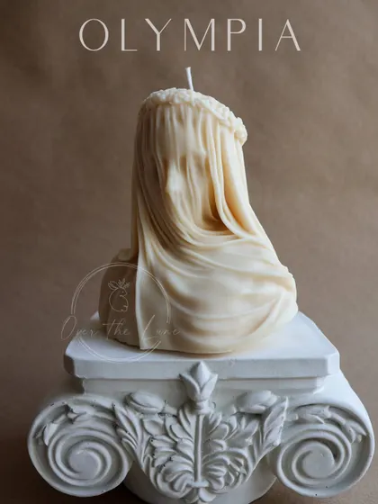 Another angle of the exquisite Veiled Lady candle, resting on a decorative pillar. The craftsmanship captures a sense of mystery and elegance.