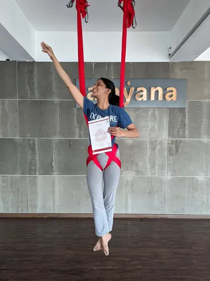 Reaching for the sky. A graduate celebrates her certification with an expressive pose.