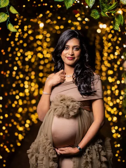 A stunning solo portrait with a magical bokeh background of fairy lights, making the mom-to-be shine.