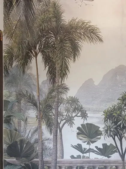 A scenic tropical mural featuring palm trees and a distant mountain landscape. This type of large-scale wallpaper can open up a room and create a beautiful, immersive view.