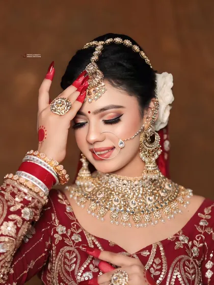A beautiful bridal portrait highlighting the harmony between the makeup, jewelry, and the bold red nails. Every element works together to create a look of timeless elegance.