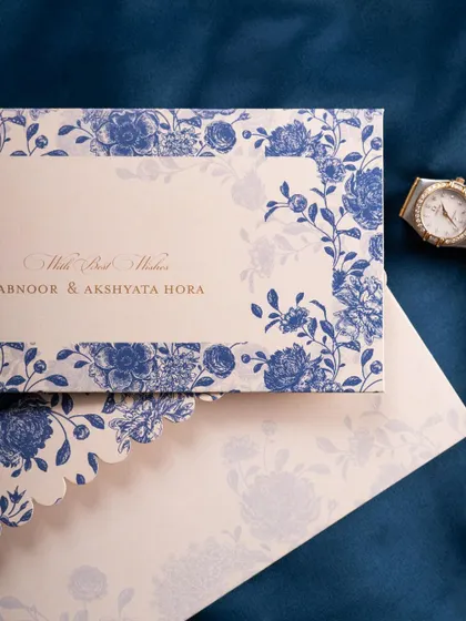 A classic flat lay of a blue floral wedding invitation and envelope. The simple, elegant composition on a dark background is timeless and effective.