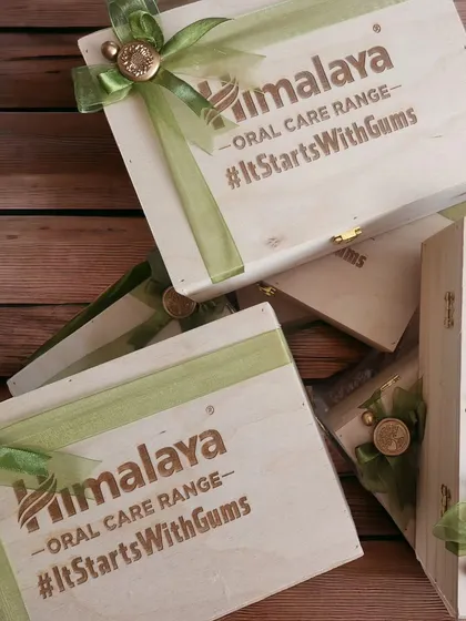 The final look of the engraved wooden boxes for Himalaya's #ItStartsWithGums campaign. Each box is finished with a custom green ribbon and wax seal, adding a touch of elegance.