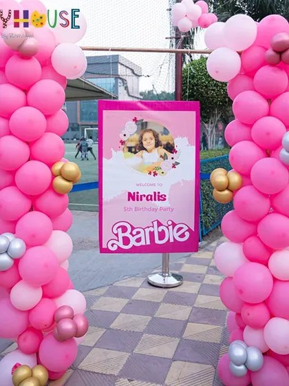 The entrance to Nirali's Barbie party, with a grand pink balloon display and a custom welcome sign.