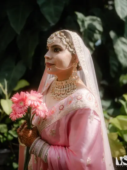 A classic bridal portrait of Archana in her beautiful pink lehenga. The soft, natural light and her serene expression make for a timeless and elegant image.