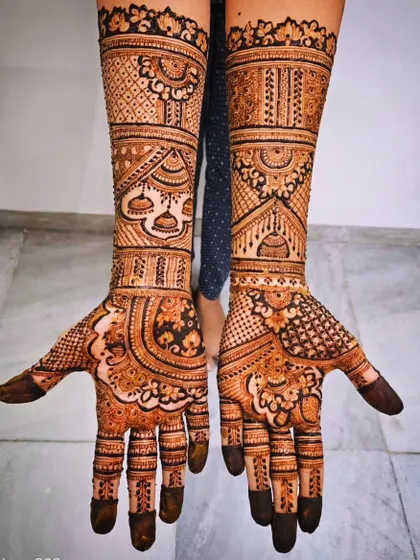 This bridal design features hanging jhumka (dangling earring) motifs, a popular and elegant element in modern mehendi art.