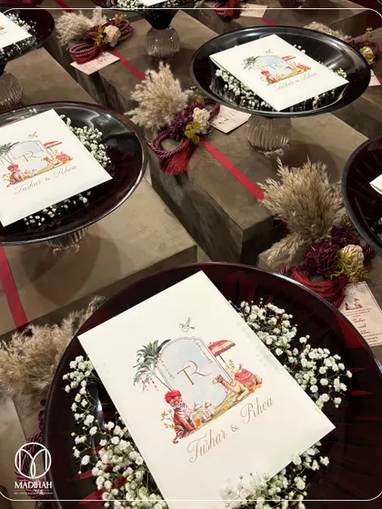 A beautiful tablescape of return favors, featuring my Crimson Crystal Bowls with personalized cards, set against rustic wooden boxes. The combination of colors and textures is warm and inviting.