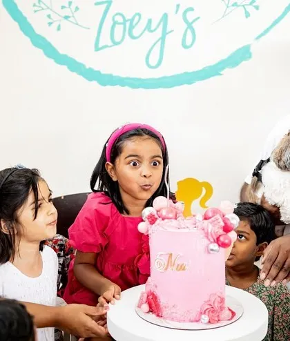 Making a wish! The anticipation and excitement on the birthday girl's face as she blows out her candles is a priceless moment. Even the family dog, Casper, is watching intently!