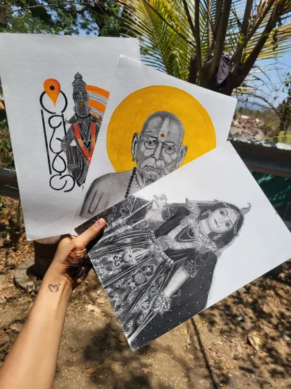 A collection of my spiritual artworks held outdoors, featuring portraits of Swami Samarth, Radha Rani, and Lord Vitthal.