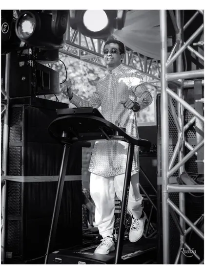 A black and white shot of the groom's unique baraat entry on a treadmill, capturing the motion and excitement of the moment.