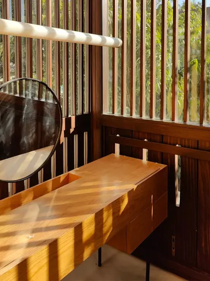 A close-up of a dressing table bathed in the morning light filtering through the wooden 'jaali'. The patterns of light and shadow become a decorative element, changing throughout the day.