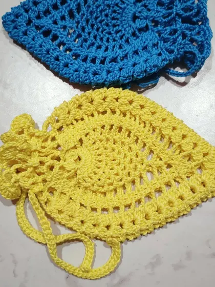 A pair of pineapple pouches in bright blue and yellow. The top of the pouch has a frilly edge that mimics the crown of a pineapple.