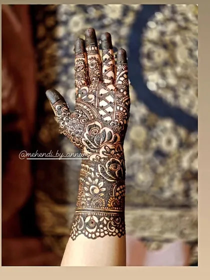 The beauty is in the details. This full-arm bridal design combines dense floral work with geometric net patterns and a beautifully detailed wrist cuff, creating a rich and textured look perfect for a bride.