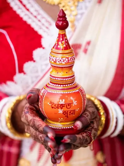 A classic gachkouto, beautifully painted with the words 'Ek Shuvo Bibaho' (A Happy Marriage). This traditional vermillion box is an essential and sacred part of the Bengali wedding ceremony.