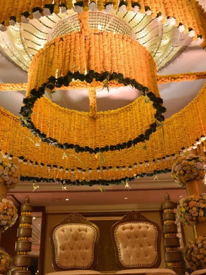 A view from below, looking up into the canopy of the marigold mandap. This angle highlights the intricate construction and the sheer volume of flowers used to create this traditional yet luxurious wedding structure.