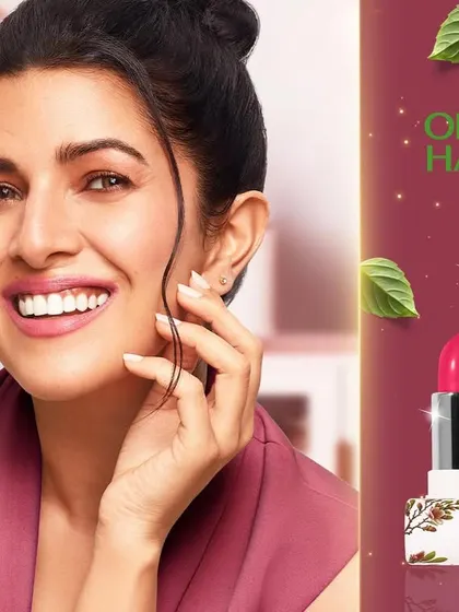 Another photograph from the Organic Harvest campaign with Nimrat Kaur. Here, she is featured with the brand's lipstick and liquid lip color, presenting a warm and trustworthy endorsement for the cosmetic line.