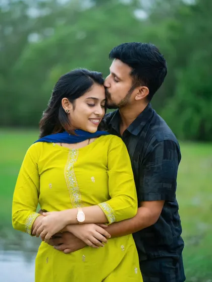 An intimate pre-wedding photo capturing a tender moment between a couple. The lush green background and soft natural light enhance the romantic and gentle mood of the portrait.