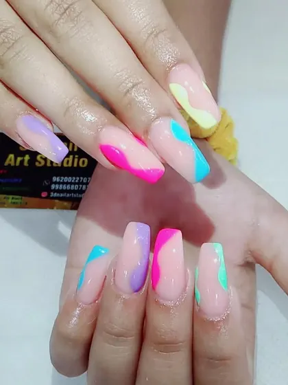 A playful and colorful abstract design with pastel waves of pink, purple, blue, and yellow on long coffin nails.