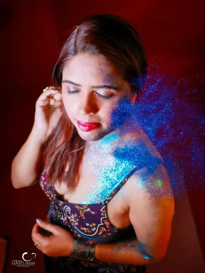 Capturing the dynamic movement of glitter being blown onto her. This shot is full of energy and a sense of transformation.