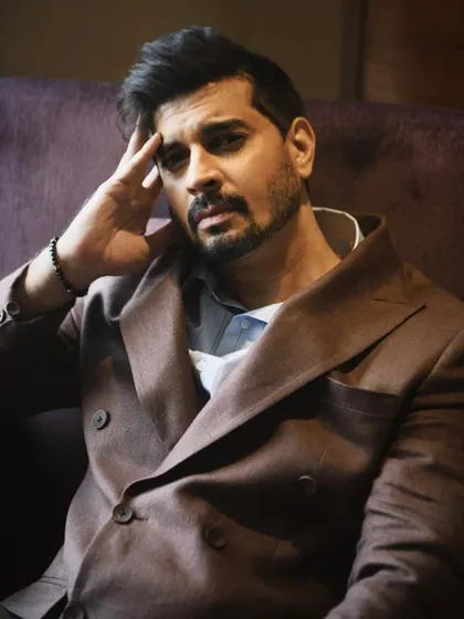 A close-up portrait of Tahir Raj Bhasin, looking directly at the camera. His expression is intense and engaging, drawing the viewer in.