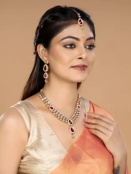 A model wearing a traditional kundan necklace set with pink stones and a matching maang tikka, ideal for wedding and festive wear catalogues.