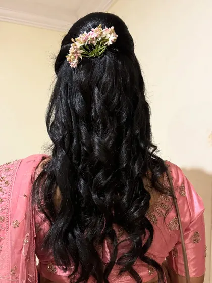 Another example of beautiful soft curls, this time for a non-bridal look. We added a small floral accessory to complement her pink saree. Curls are versatile and suit almost any hair length.