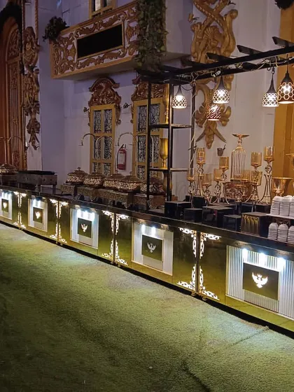 A wide shot of our illuminated buffet counter inside a grand, traditional venue. The length of the setup demonstrates our capacity to handle large-scale events without compromising on design or elegance.