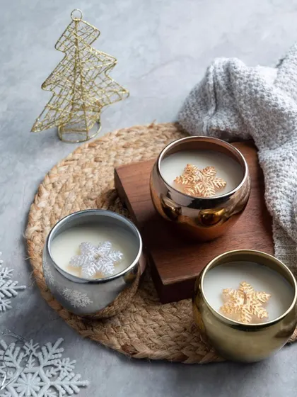 These metallic jar candles are a modern take on Christmas decor. I pour scented wax into these beautiful gold, silver, and rose gold bowls, each with a little snowflake wax melt on top.