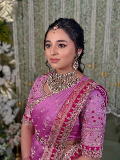 A three-quarter profile shot that captures the beautiful details of the makeup and the intricate embroidery on the saree blouse.
