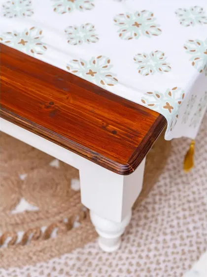 A detailed shot of the corner of the farmhouse coffee table, showing the quality of the wood finish and the smooth, rounded edges.