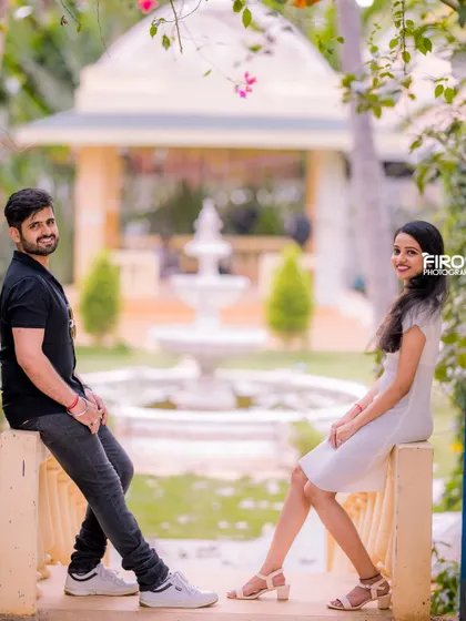 A relaxed and stylish portrait of a couple on a balcony. The soft, natural light and the garden background create a very serene and beautiful atmosphere.