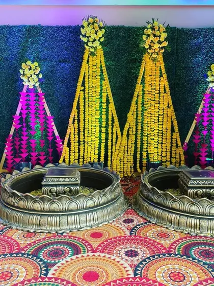 A traditional Haldi setup with large brass urlis and backdrops made of marigold and tuberose garlands, creating a classic and auspicious look.