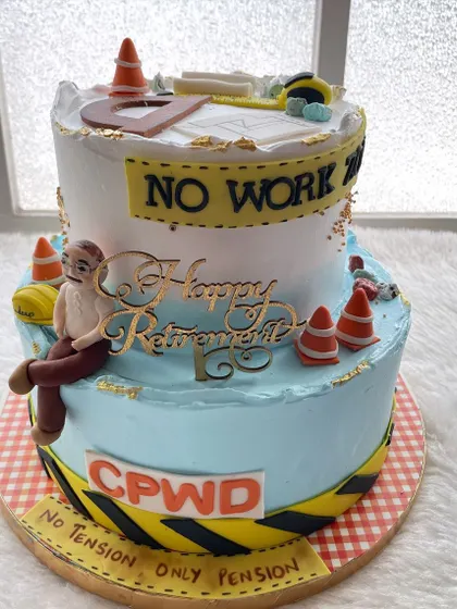 A two-tier retirement cake for a civil engineer from CPWD. The design features blueprints, a hard hat, and a funny caricature, celebrating the end of a long career.